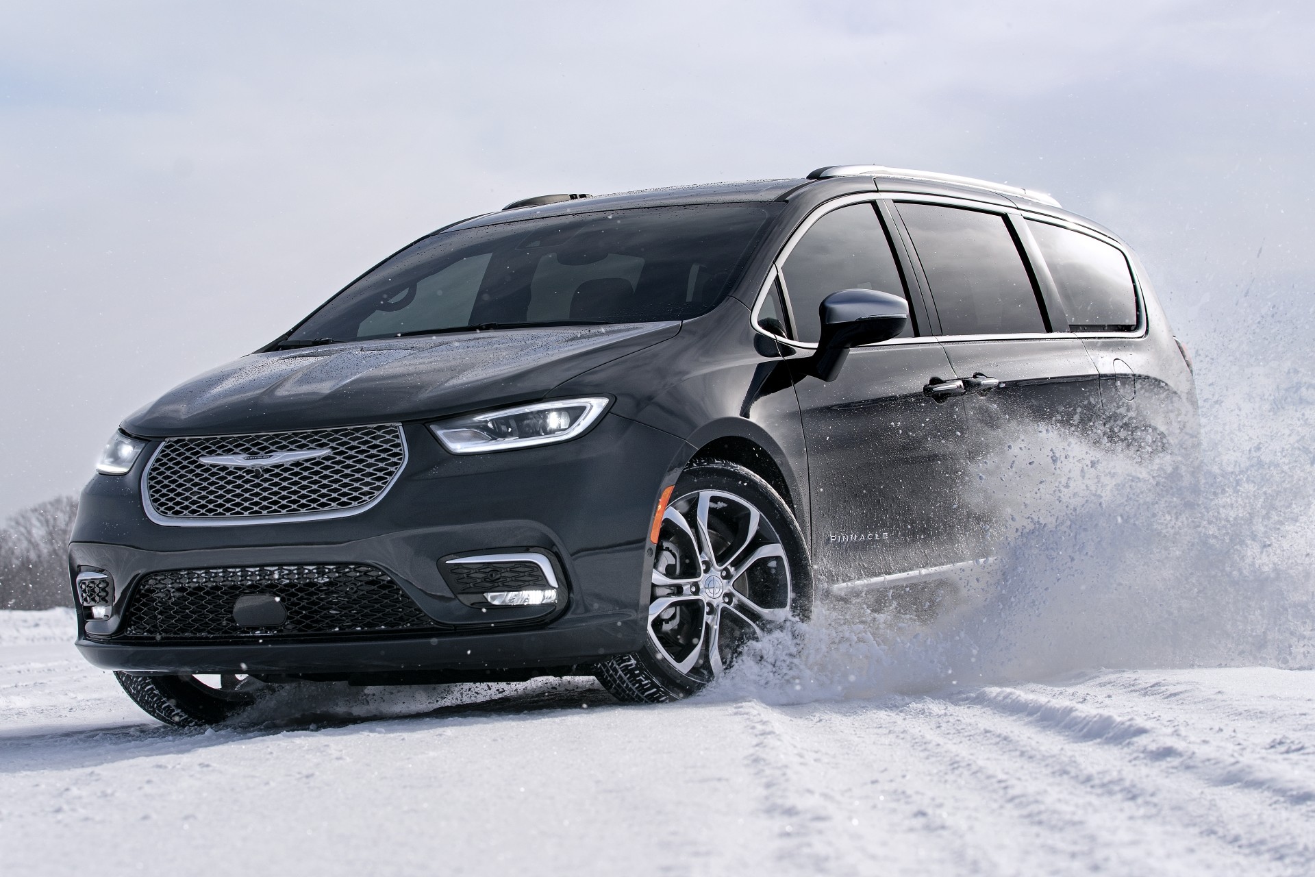 Exterior view of the new 2021 Chrysler Pacifica driving down a road.