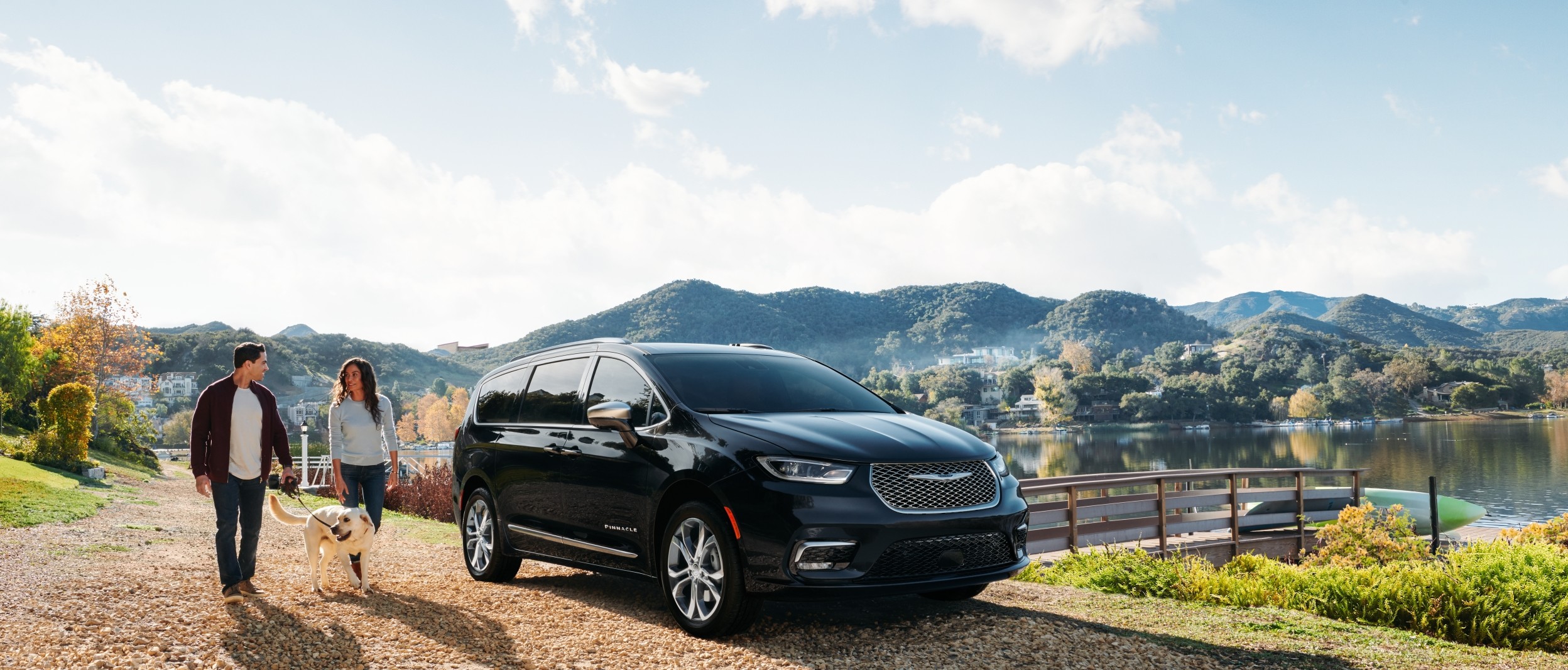 The new 2021 Chrysler Pacifica parked near a lake with mountains behind