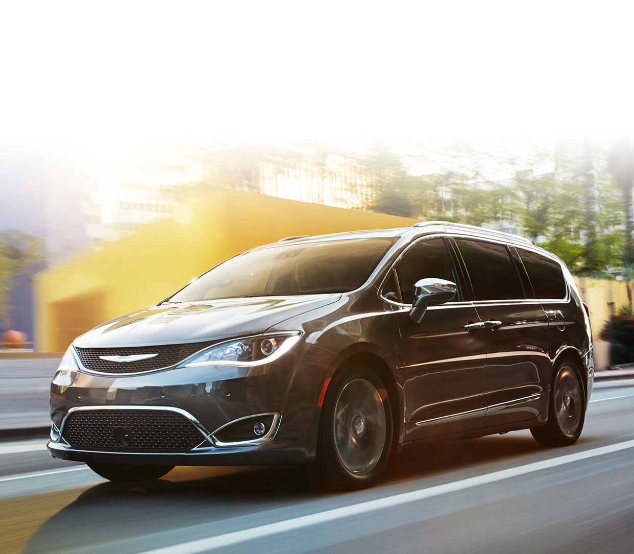Une Chrysler Pacifica grise roule à travers la ville