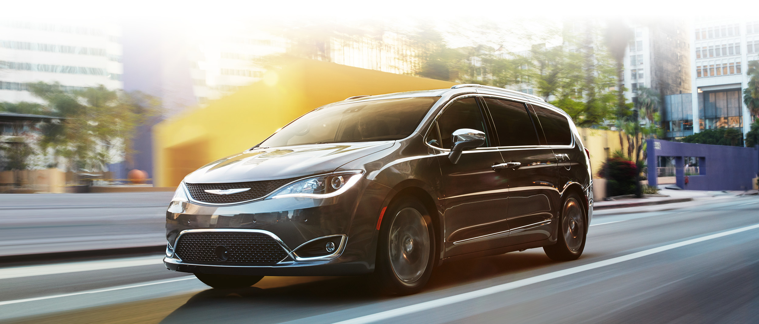 Une Chrysler Pacifica grise roule à travers la ville