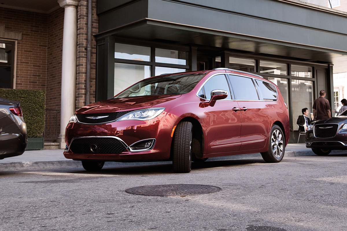 Chrysler Pacifica Hybrid 2019 avec extérieur rouge, stationnée devant un immeuble