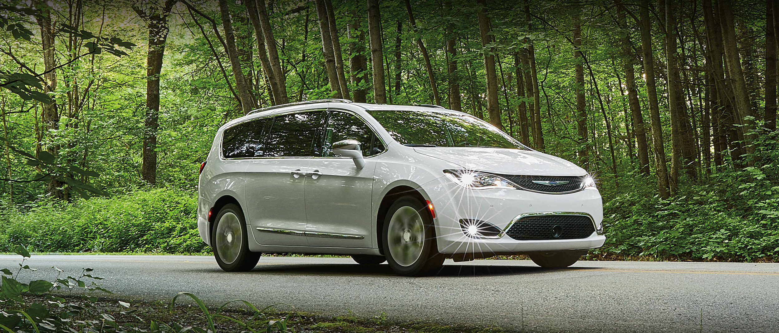 Silver Chrysler Pacifica Driving Through the City