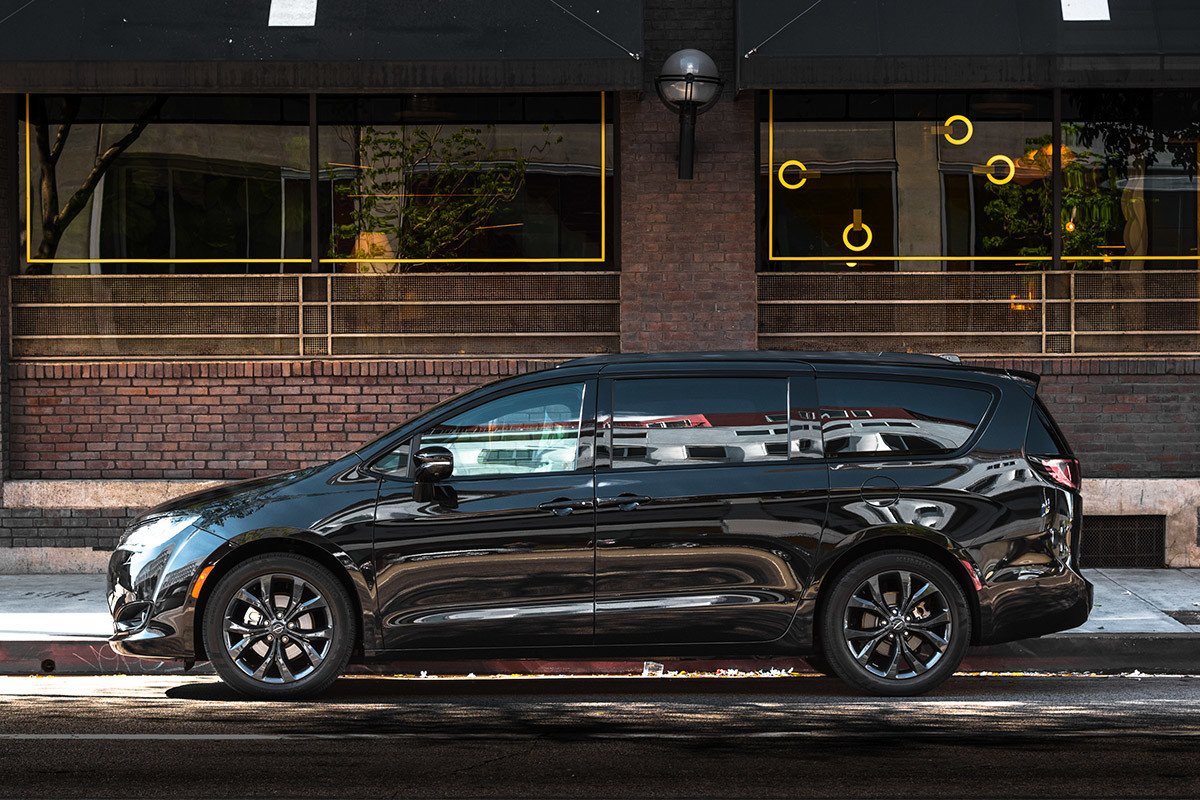 Une Chrysler Pacifica Hybrid 2020 noire, stationnée devant un immeuble.