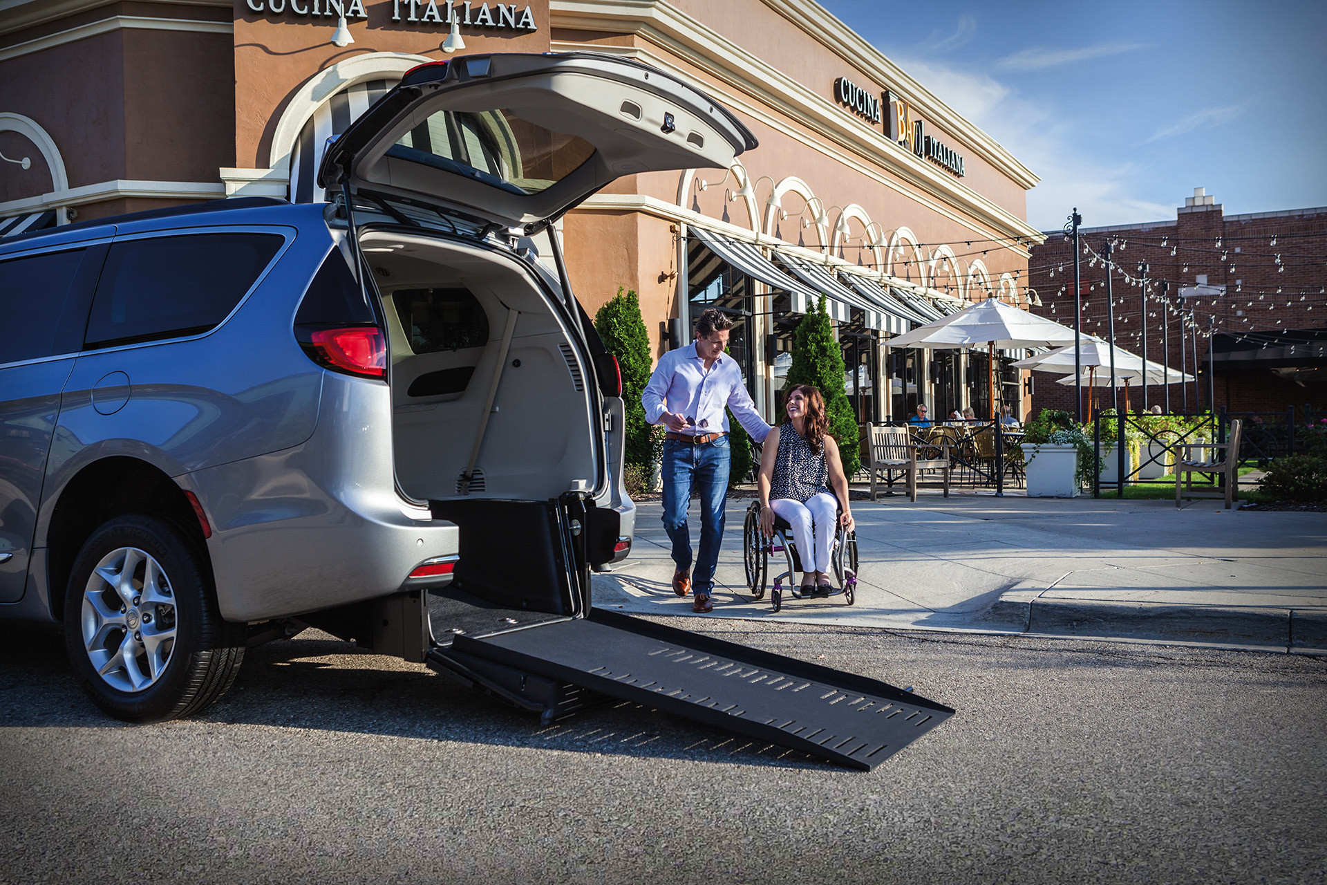 White 2020 Chrysler Pacifica with its trunk open and an entry ramp unloaded.
