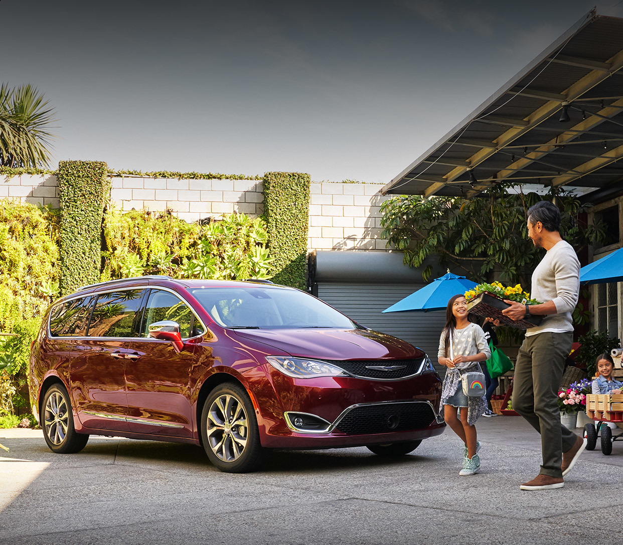 Une famille marchant vers une Chrysler Pacifica 2020 rouge.