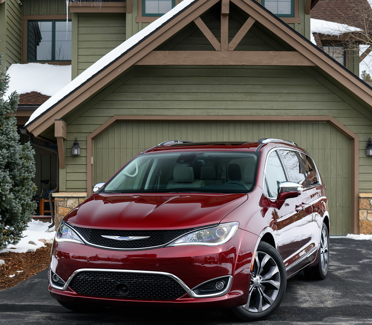Burgundy Chrysler Pacifica parked on the driveway of an olive green home.