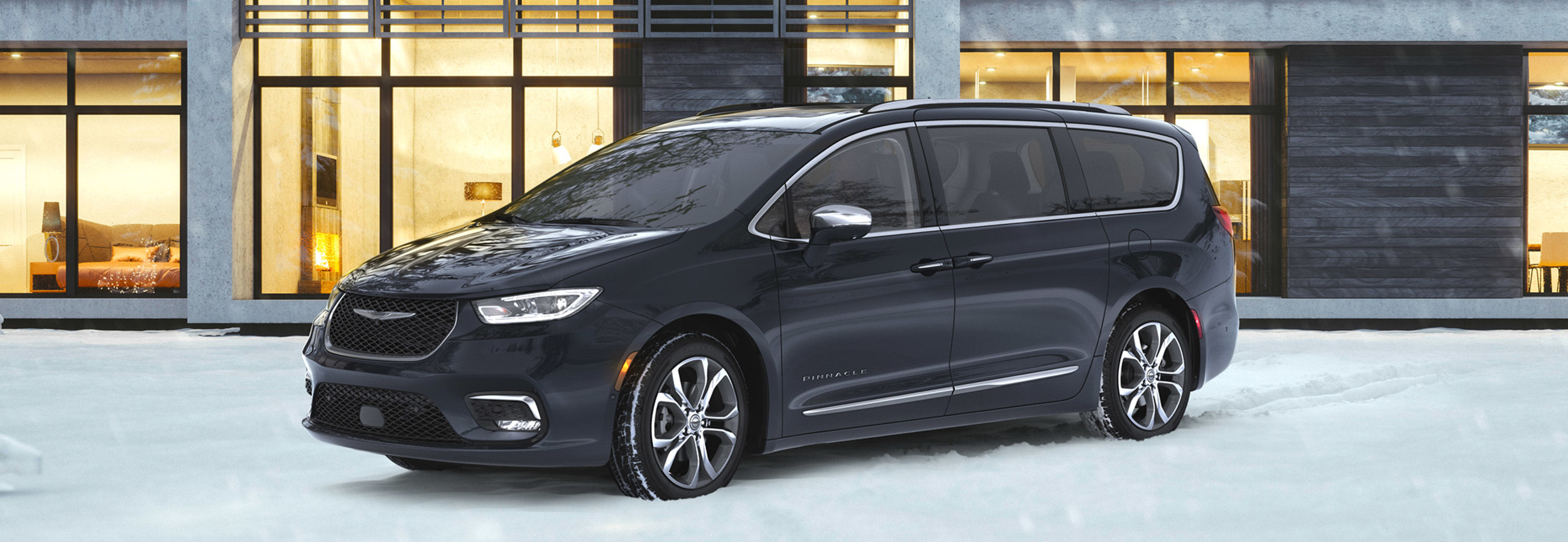 A black 2022 Chrysler Pacifica parked on a snowy highway.