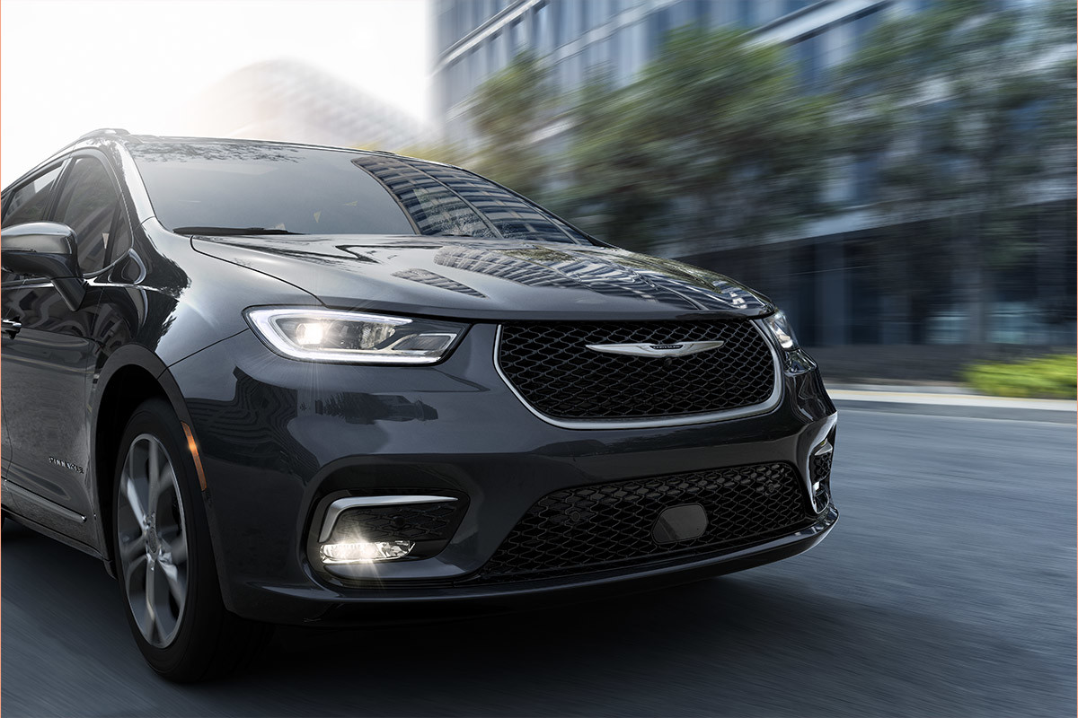 A black 2022 Chrysler Pacifica driving in the town.