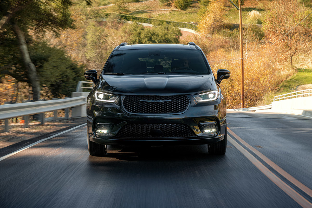 Passenger Safety — Check Front view of a blue Chrysler Pacifica driving on a highway.