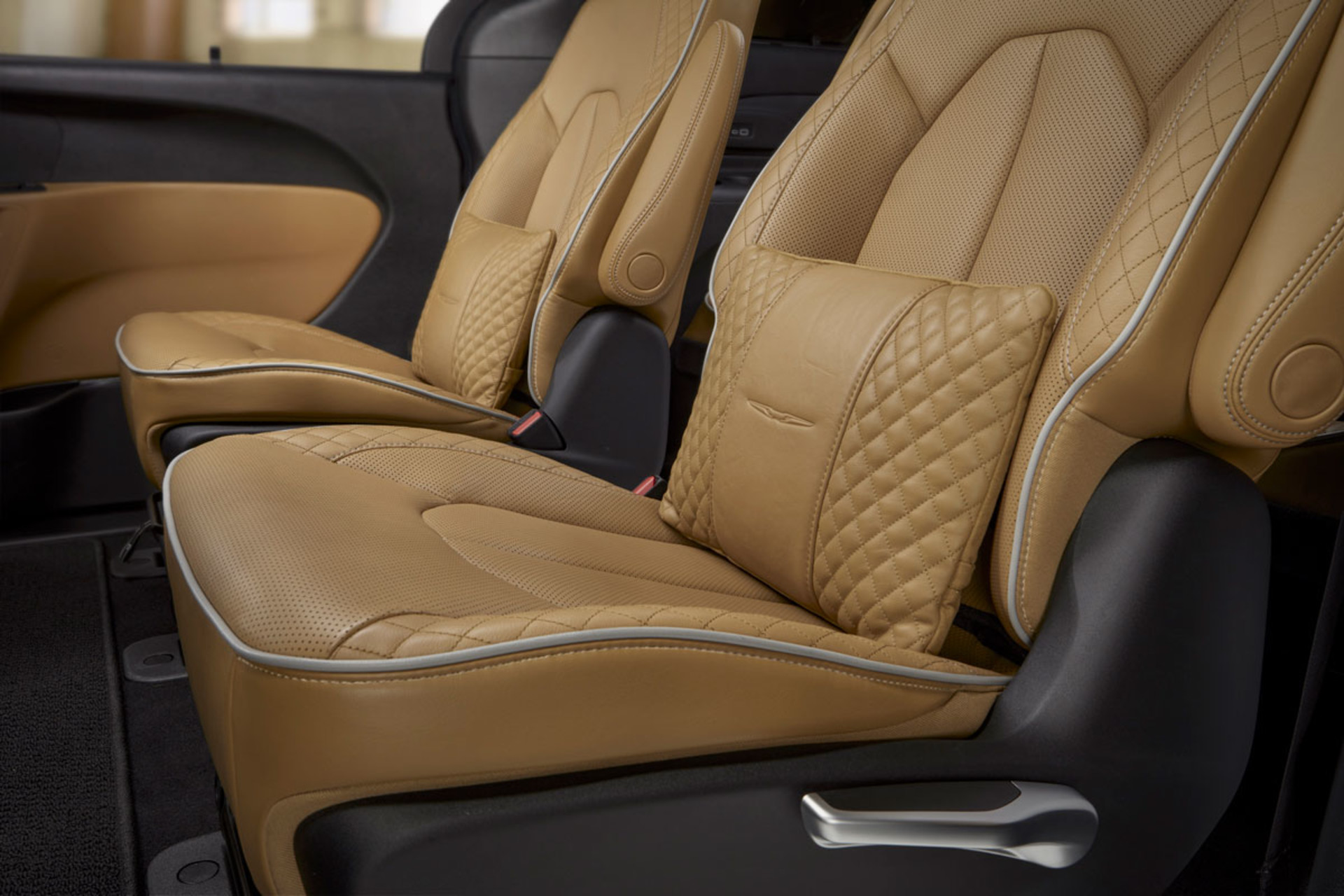 Front interior of a 2022 Chrysler Pacifica showing steering wheel and carmel interior seating.