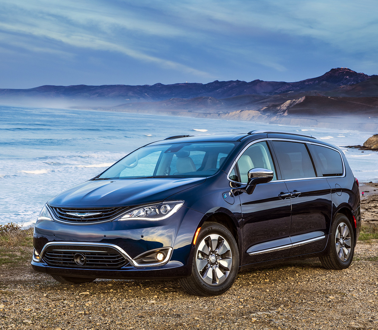 Une Chrysler Pacifica Hybrid bleue roule à vive allure à travers les plaines