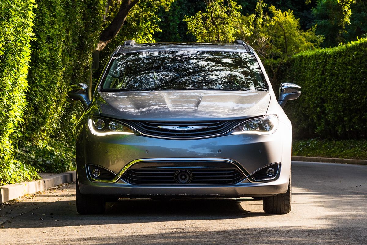 2019 Chrysler Pacifica Hybrid with silver exterior driving in the city.