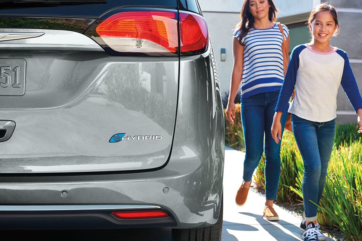 2019 Chrysler Pacifica Hybrid woman and child walking next the minivan