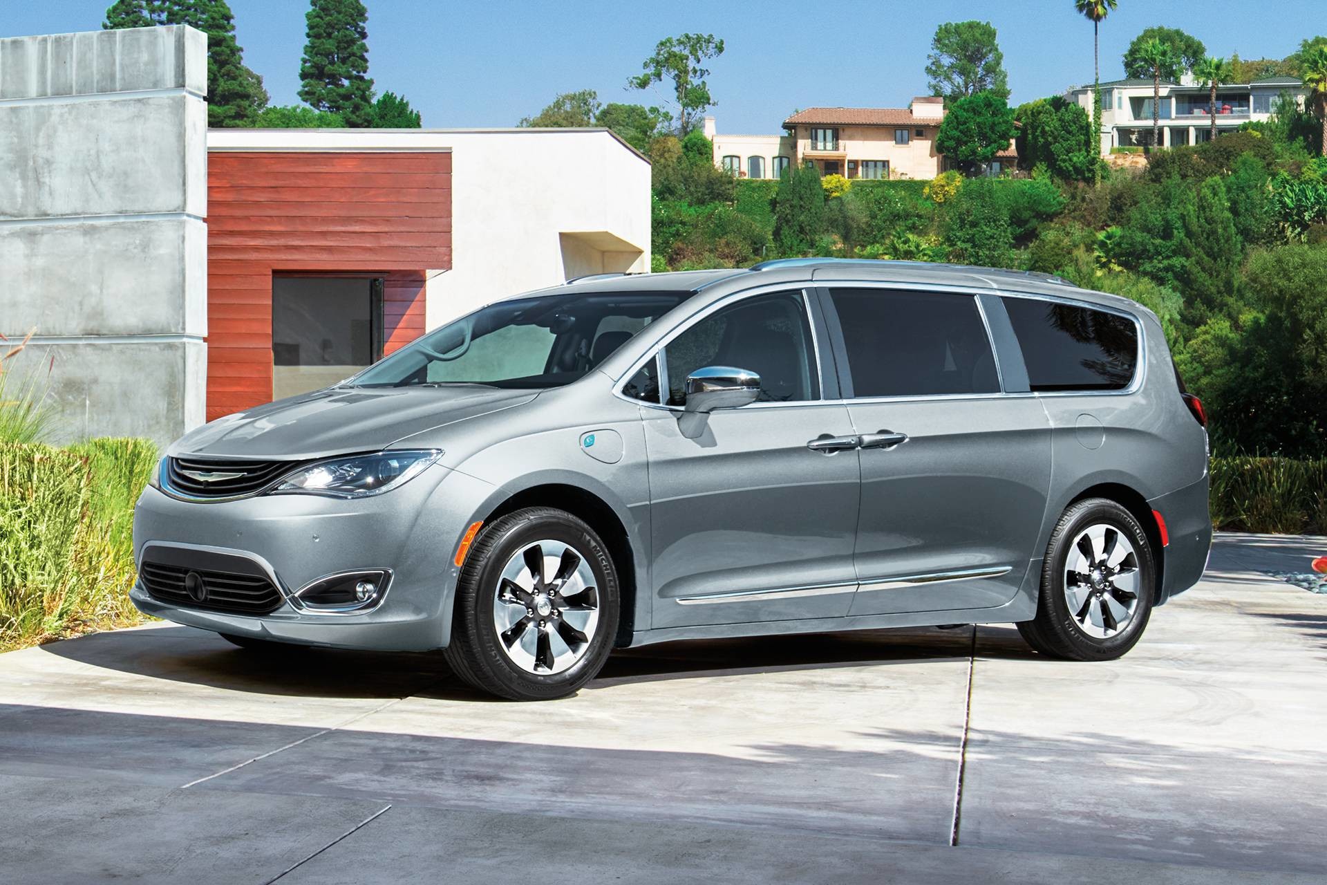 2019 Chrysler Pacifica Hybrid exterior shot of a Hybrid charging at a home, shown in silver