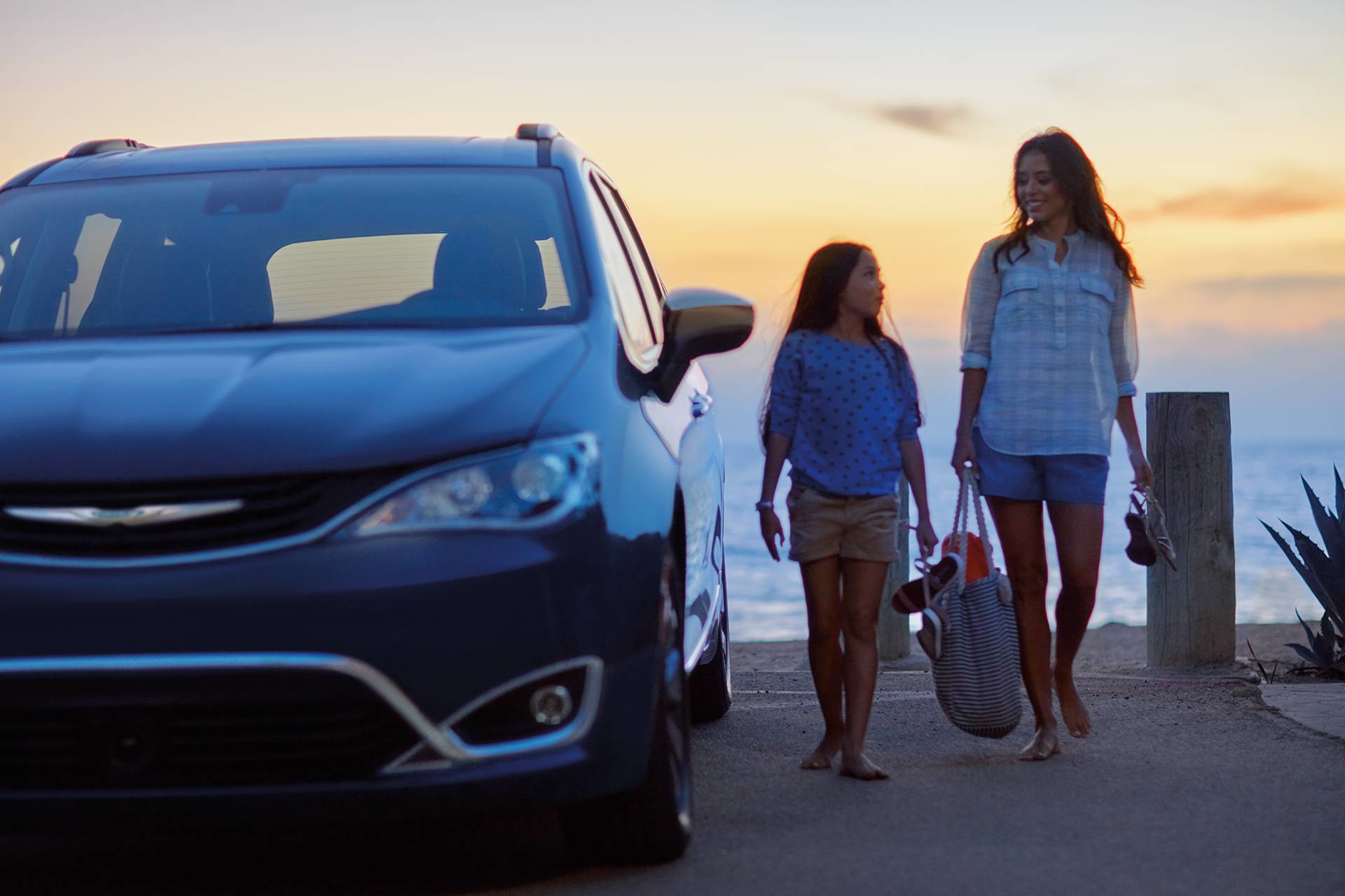 2019 Chrysler Pacifica Hybrid exterior front view with family next to car