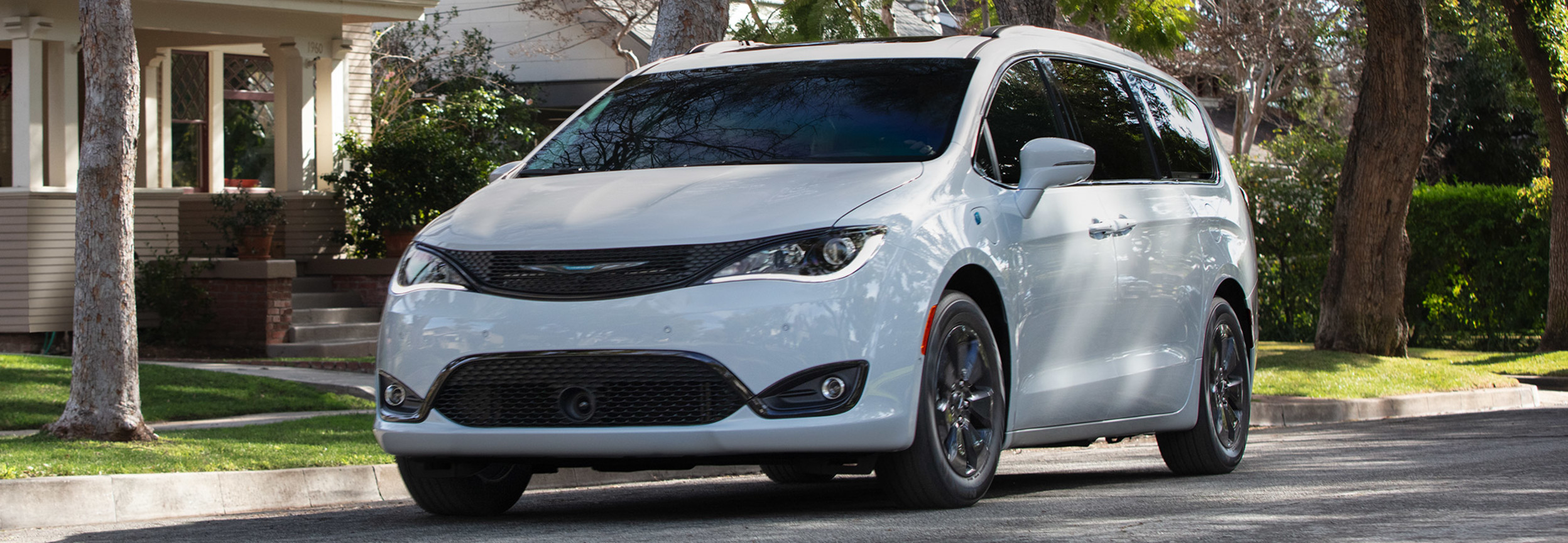 White 2020 Chrysler Pacifica Hybrid parked on the side of the road in a quiet neighbourhood
