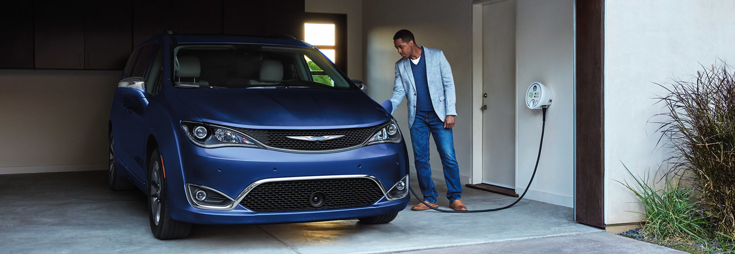 Chrysler Pacifica Hybrid 2020 bleue en cours de chargement dans le garage.