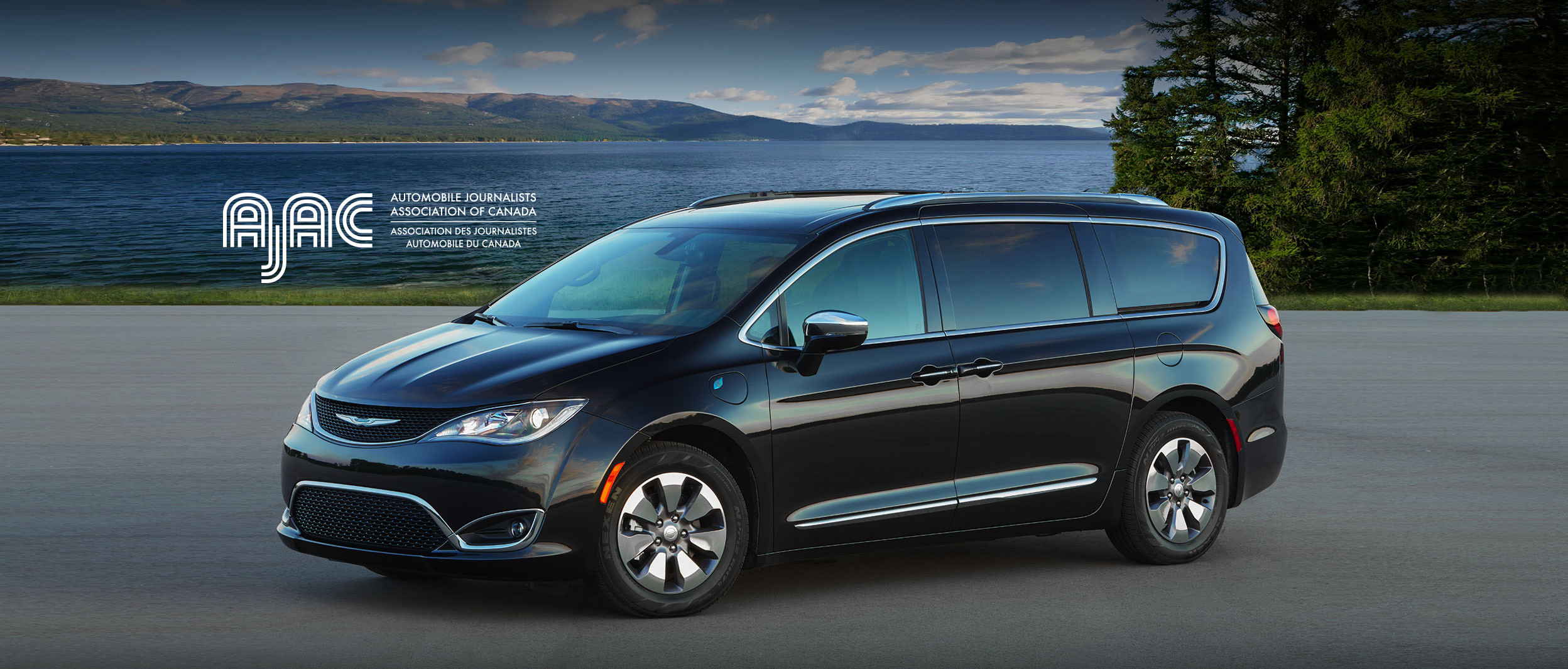 Black 2020 Chrysler Pacifica Hybrid parked in front of a lake with AJAC logo.