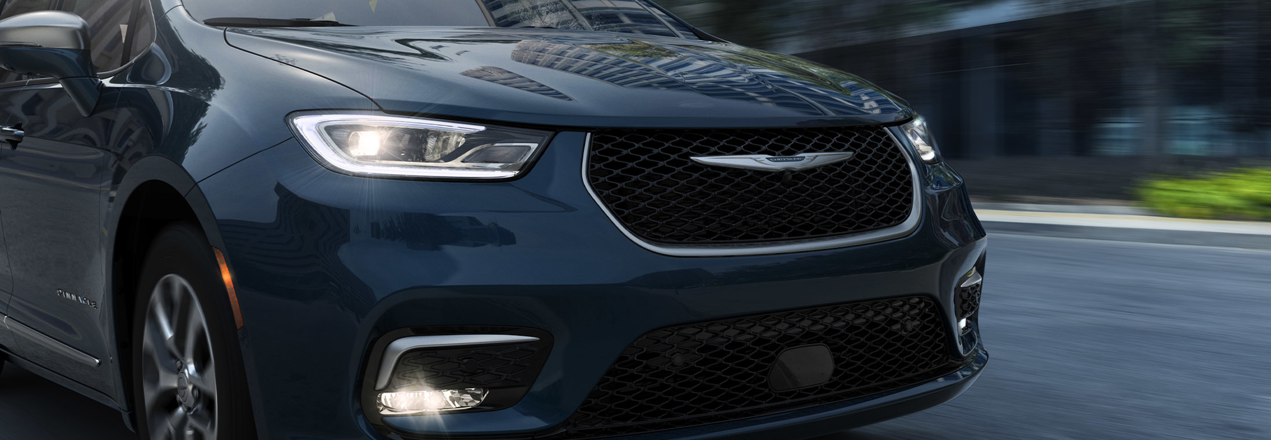 Gros plan avant d’une Chrysler Pacifica Hybrid 2021 bleue roulant à toute vitesse