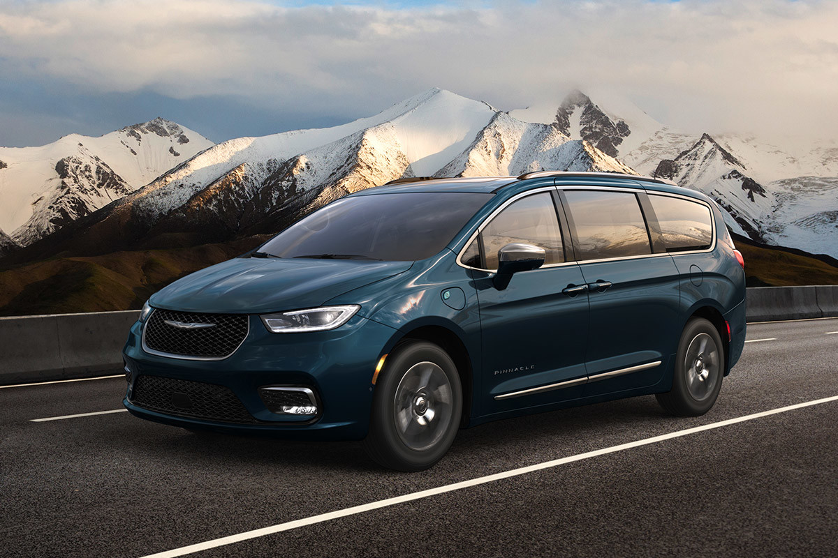Vue latérale d’une Chrysler Pacifica Hybrid 2021 sur une route entourée de montagnes enneigées