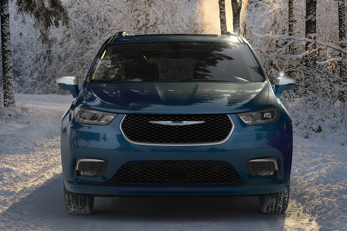 Vue de face d’une Chrysler Pacifica Hybrid 2021 stationnée dans une forêt enneigée