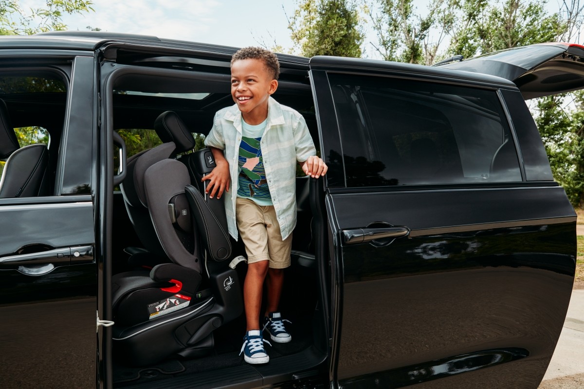 A child getting out of a black 2021 Chrysler Pacifica Hybrid