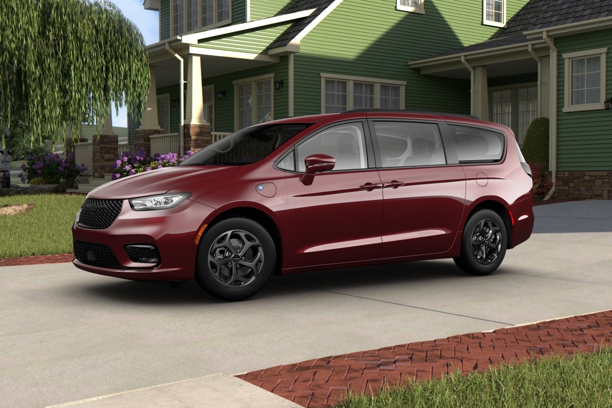 Side view of a maroon 2021 Chrysler Pacifica Hybrid parked in front of a suburban house