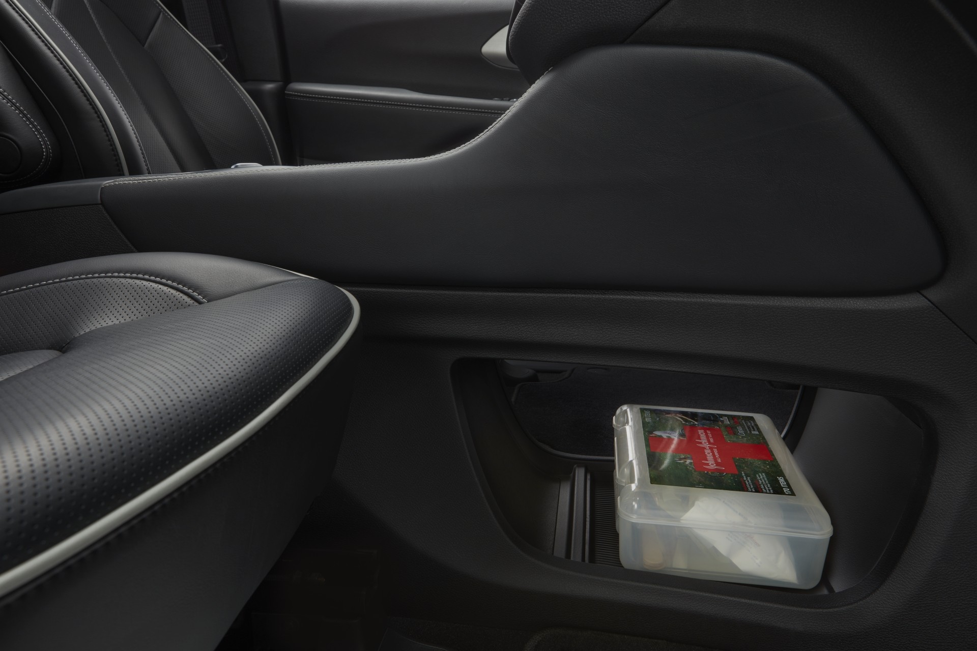 Gros plan d’une trousse de premiers soins dans l’espace de rangement ouvert sous la console de la Chrysler Pacifica Hybrid 2021.