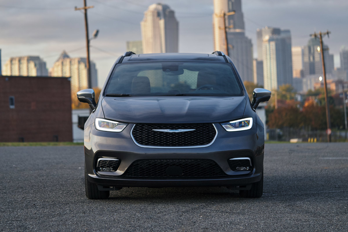 Front of a grey 2022 Chrysler Pacifica Hybrid 1.0 parked in front of a city skyline