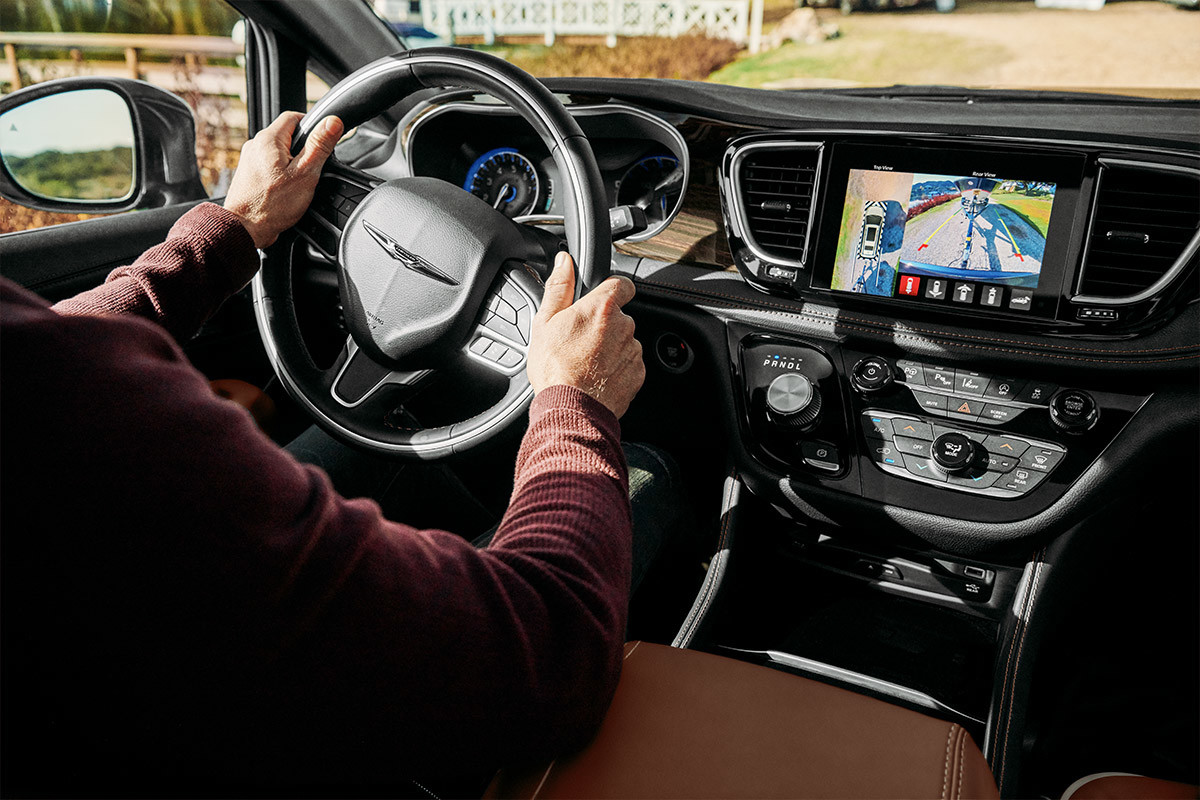 A close up of the front dash of a 2022 Chrysler Pacifica Hybrid with focus on the 360 surround view camera on the multimedia centre
