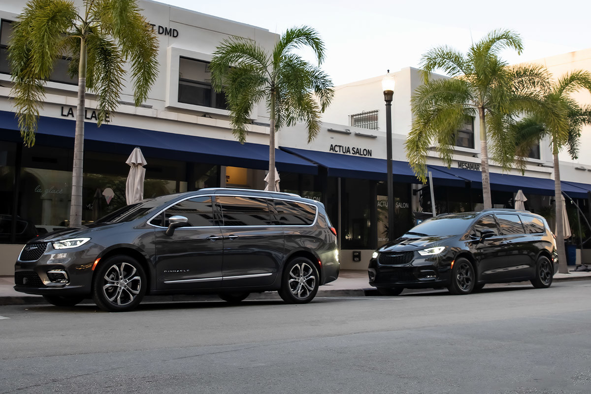 Two 2022 Chrysler Pacifica Hybrid parked next to each other in parallel along a city road