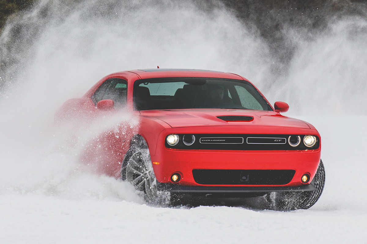 Front view of the red 2019 Dodge Challenger driving through a snowy mountain
