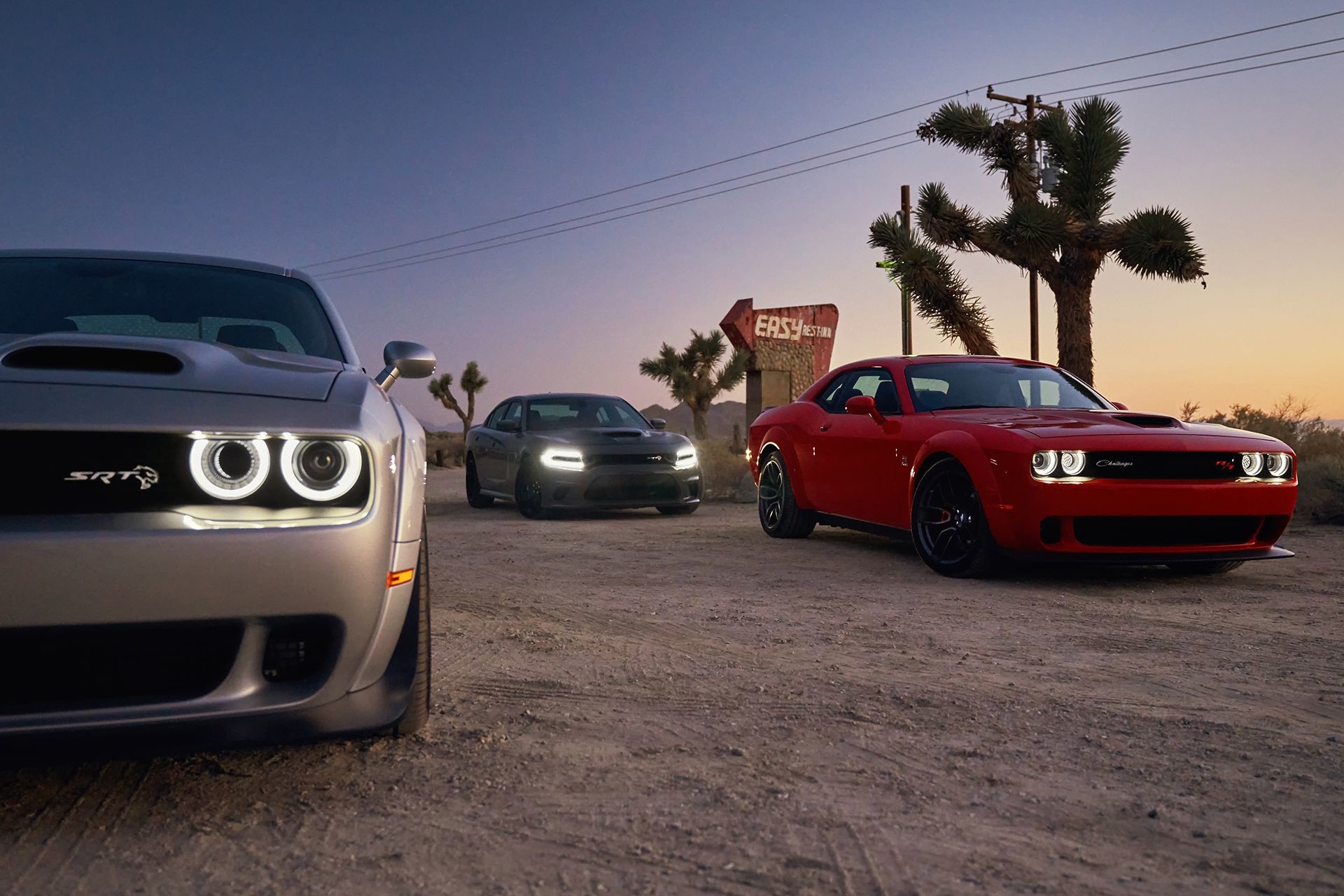 Deux Dodge Challenger 2019 et une Dodge Charger stationnées dans le désert