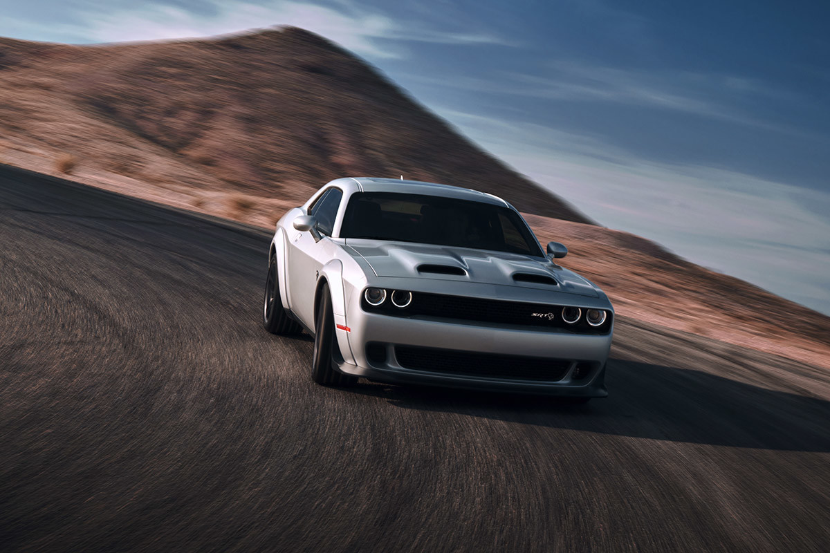 Silver 2021 Dodge Challenger being driven through a corner on a desert road.