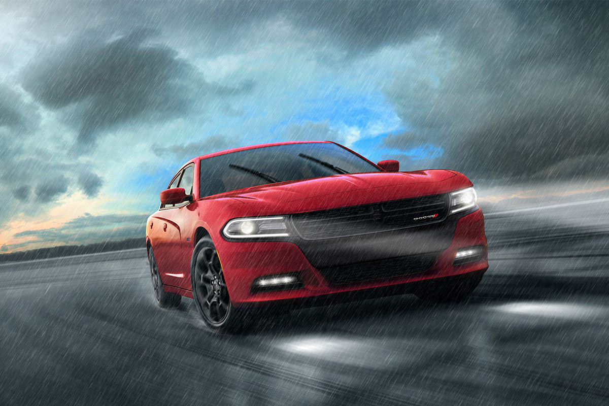 Une Dodge Charger rouge orangé roule à vive allure dans les rues d’une ville