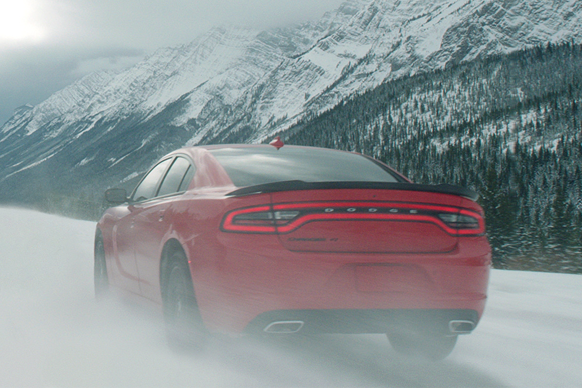 Une Dodge Charger 2020 rouge roulant sur une route près d’une zone urbaine
