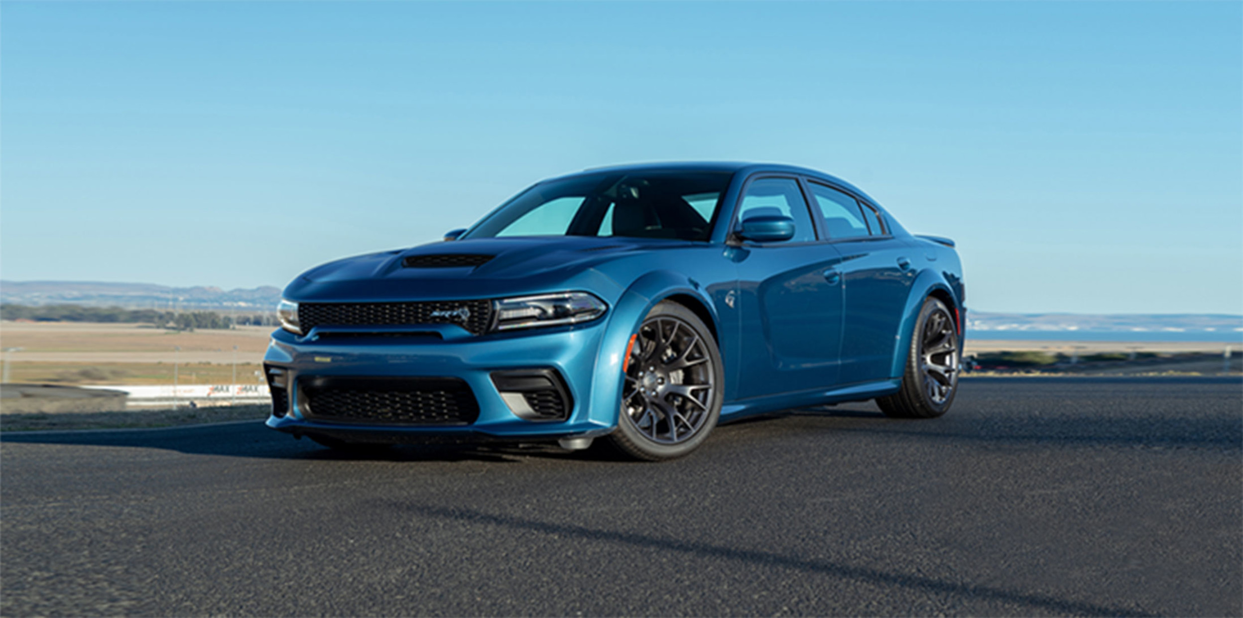 Blue Dodge Charger GT parked on road.