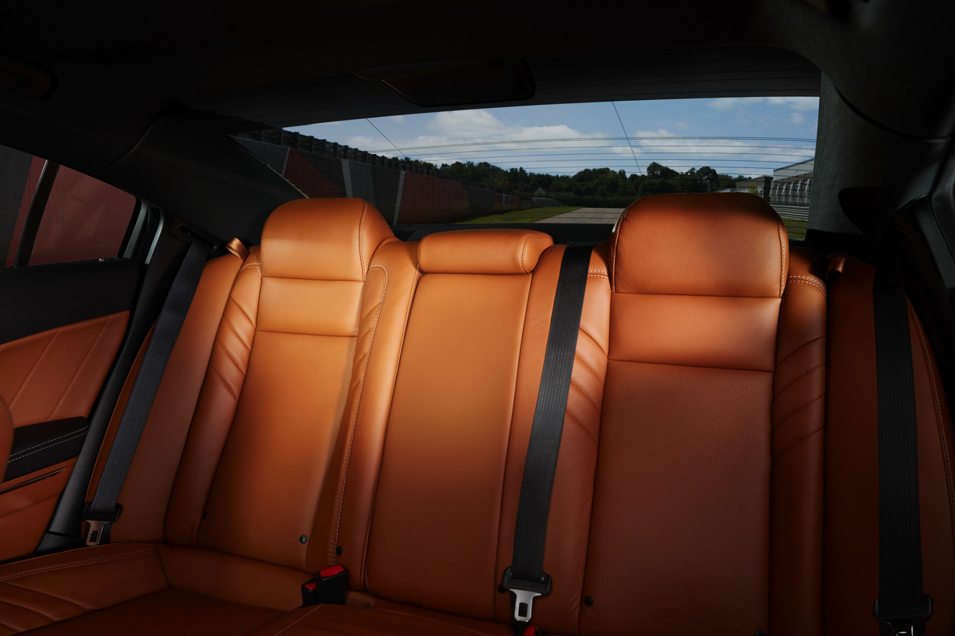 Vue intérieure des sièges arrière d’une Dodge Charger SRT Hellcat 2021 revêtus de cuir Laguna sépia avec empiècements perforés et coutures contrastantes argent.