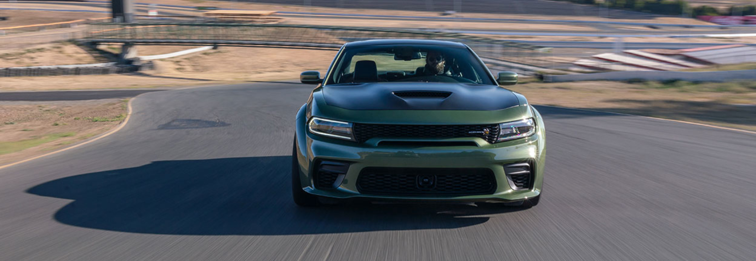 Dodge Charger 2022 blanche garée sur une route forestière.