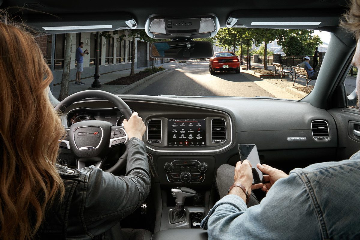 Front interior of a 2022 Dodge Charger driven by a woman with a man in the passenger seat