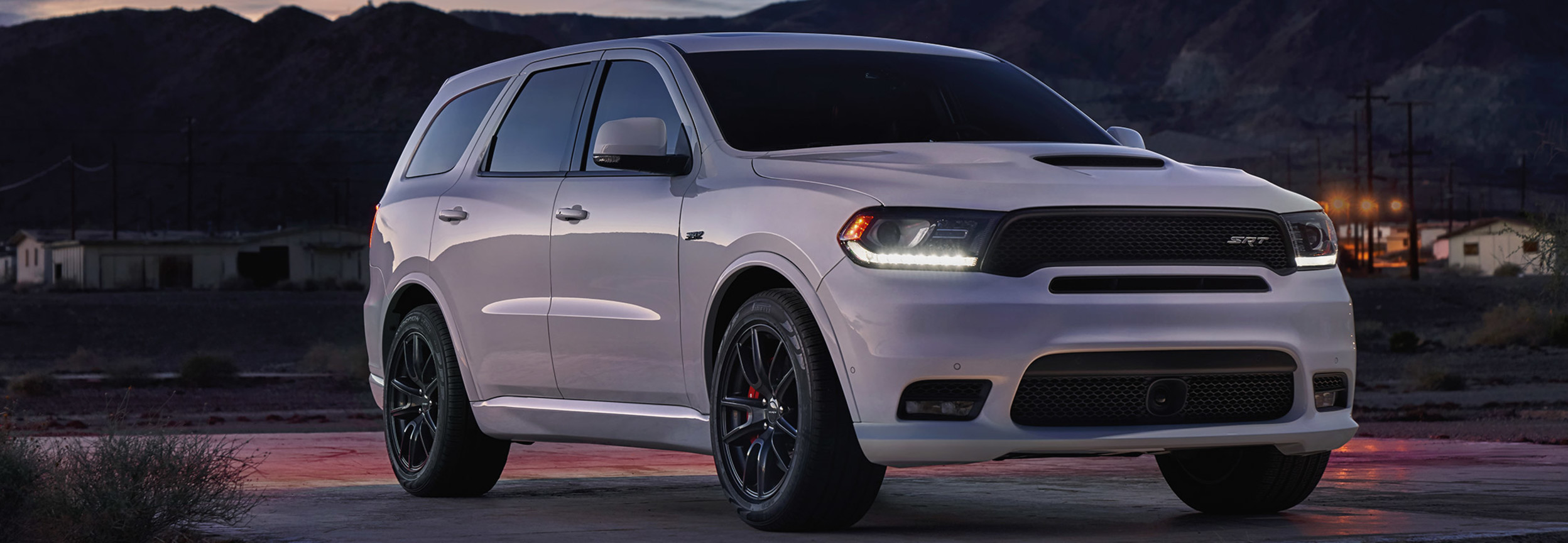 Dodge Durango SRT 2020 blanc stationné sur une plate-forme pavée au coucher du soleil.