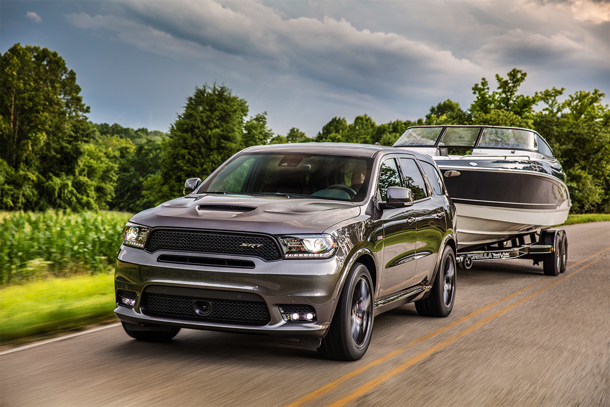 Un Dodge Durango 2020 remorquant un bateau en roulant sur une route de campagne