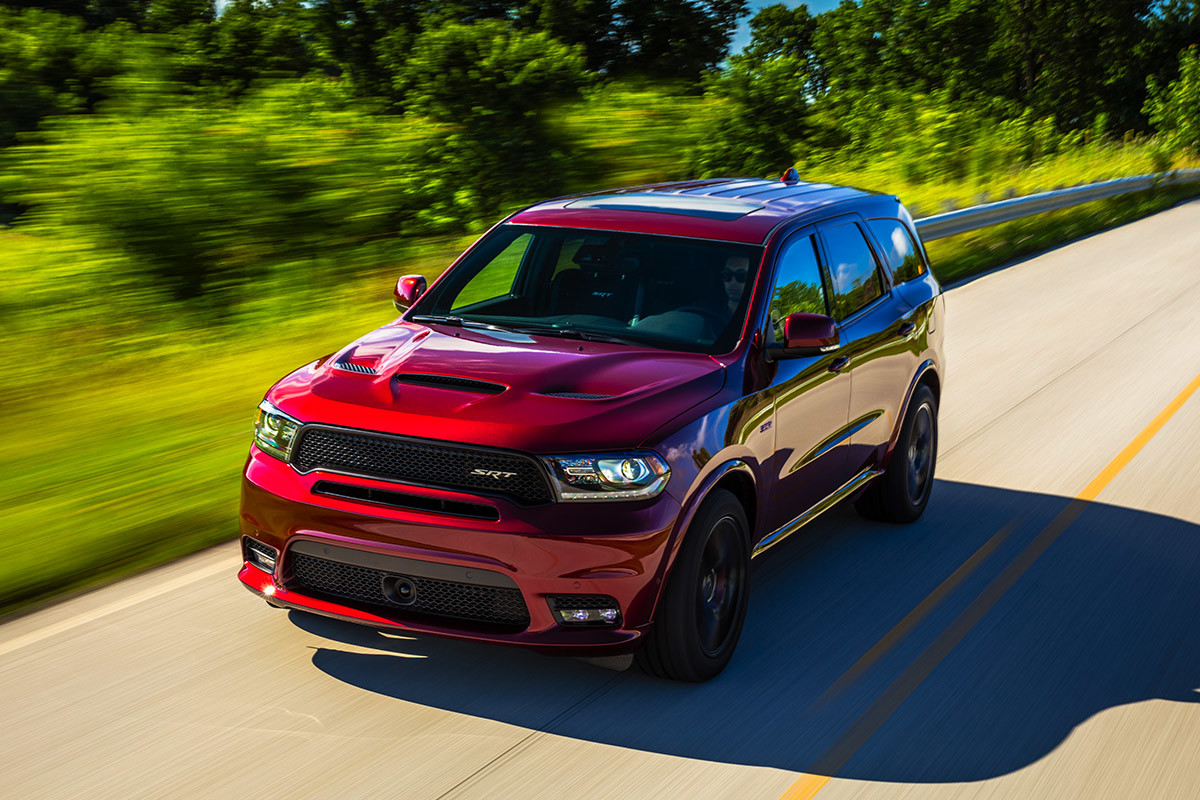 Red 2020 Dodge Durango being driven on a country road beside fields in daytime