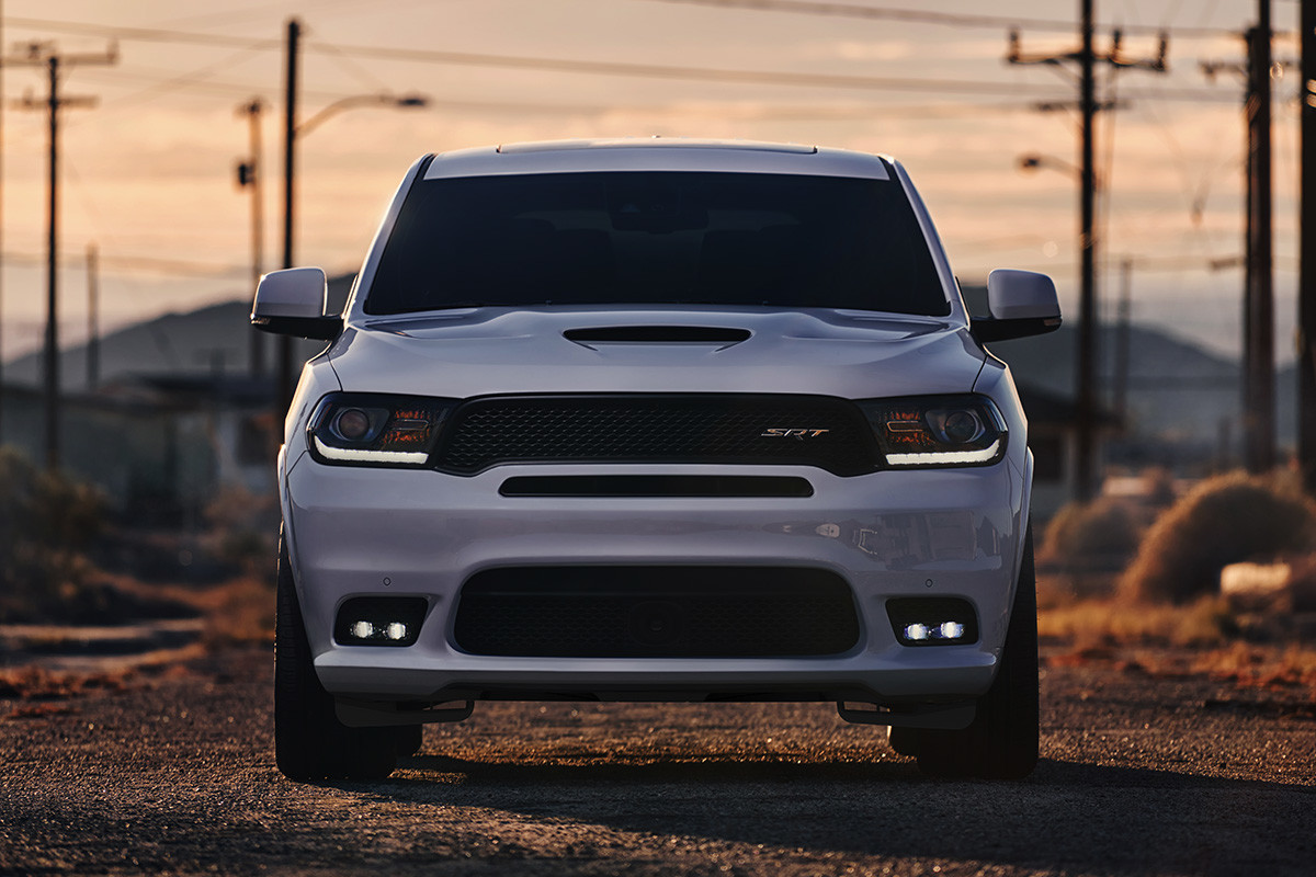 Un Dodge Durango 2020 blanc roulant sur une route de gravier en banlieue.