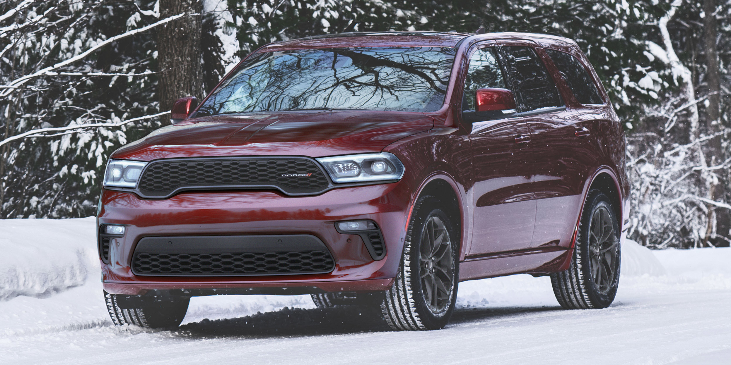 Durango GT rouge intense roulant sur une route enneigée dans les bois.