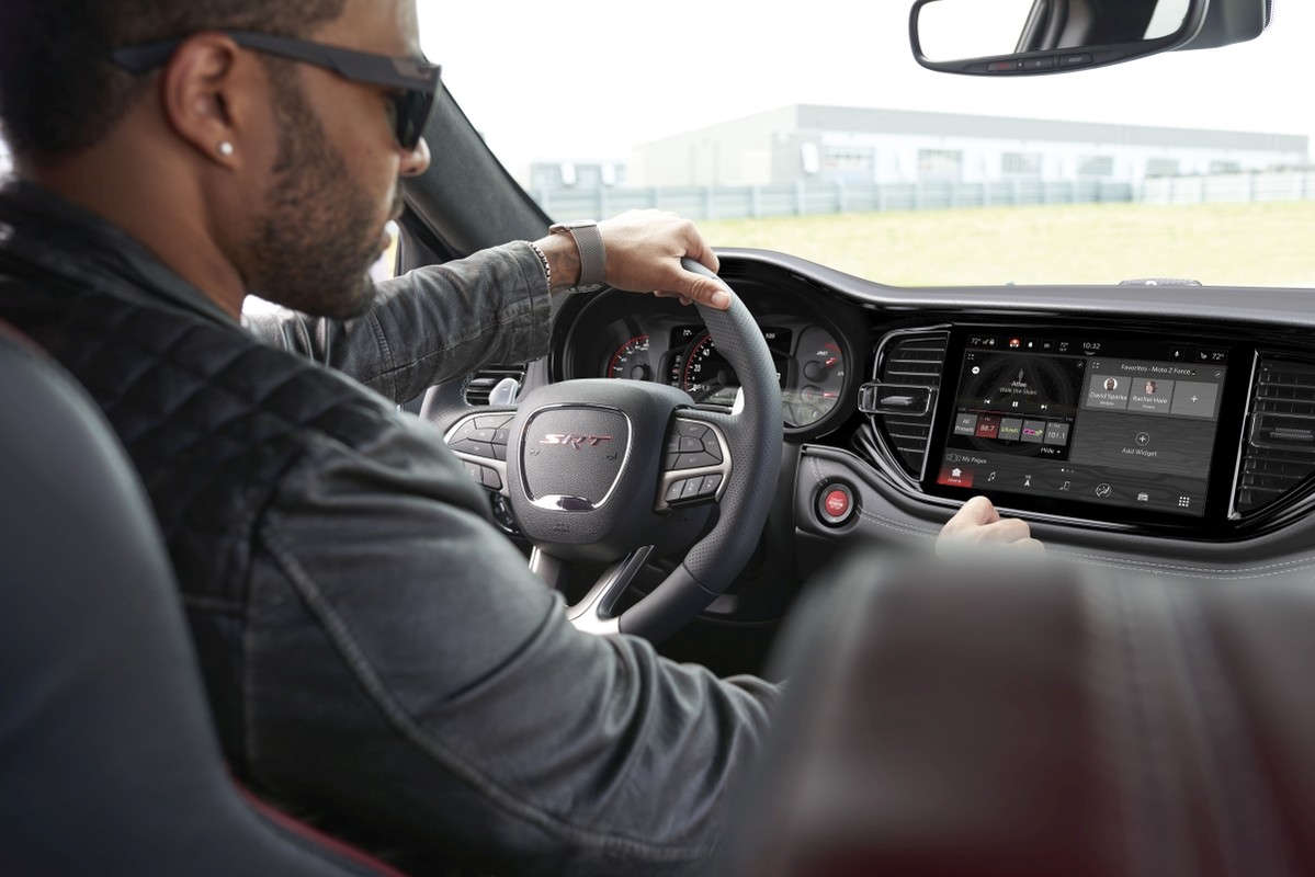 Vue intérieure de l’habitacle du Dodge Durango aux garnitures rouges avec un homme au volant.