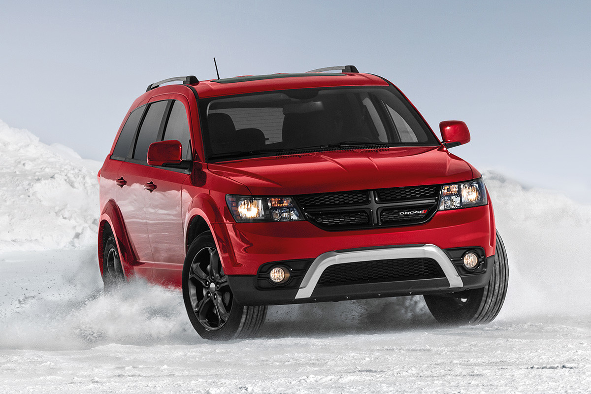 Vue de face de la Dodge Journey 2019, illustrée en rouge, roulant à travers un champ enneigé