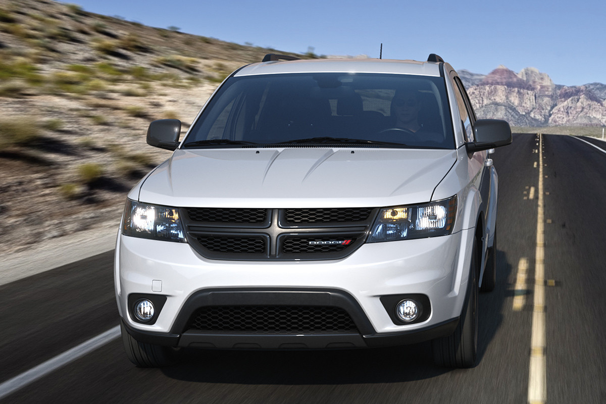 White 2019 Dodge Journey being driven down a freeway with hills and mountains in the background.