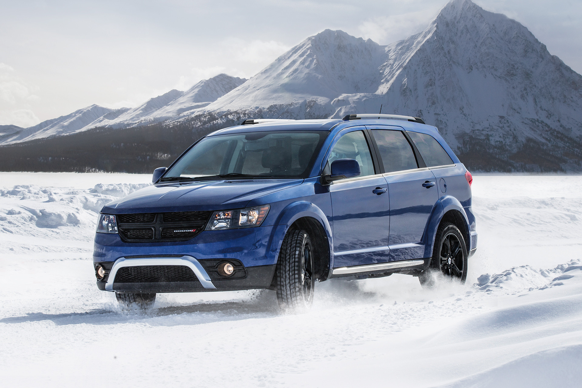 Vue de face du Dodge Journey 2019, illustré en bleu, roulant dans la neige en montagne