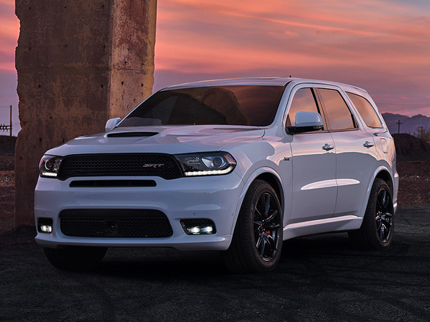 White 2020 Dodge Durango, parked in front of a tall rectangular concrete column in a suburban area.